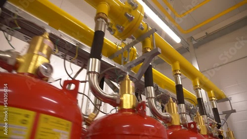 Modern professional industrial fire extinguishing system. Rows of red metal cylinders of fire extinguishers in a special fire safety room. Fire prevention. Means for extinguishing fires.