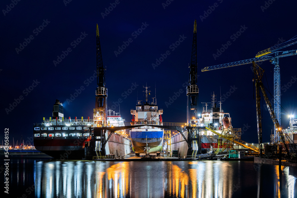 general cargo vessel in floating dock for maintenance at night
