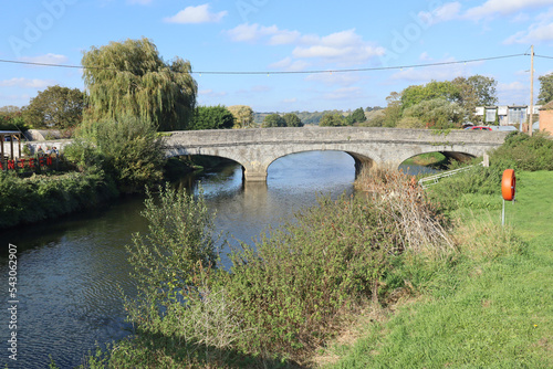 A stone three arch bridge over the River Parrett in Langport, Somerset as it flows through the public park