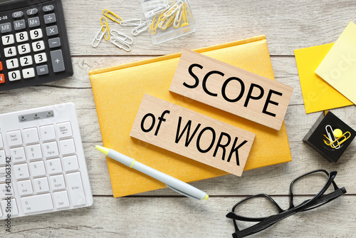 Scope Of Work text on wooden blocks on yellow notepad