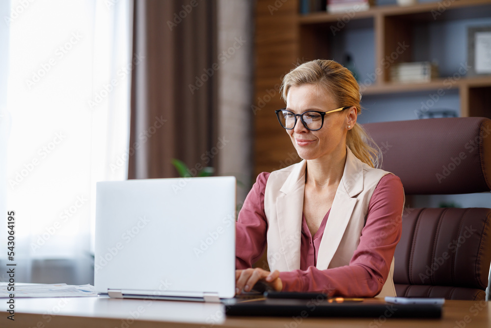 Portrait of beautiful businesswoman working with laptop at office. Texting messages, browsing internet, studying online, remote working. Business concept. Portrait of modern successful female leader Portrait of beautiful businesswoman working with laptop at office. Texting messages, browsing internet, studying online, remote working. Business concept. Portrait of modern successful female leader