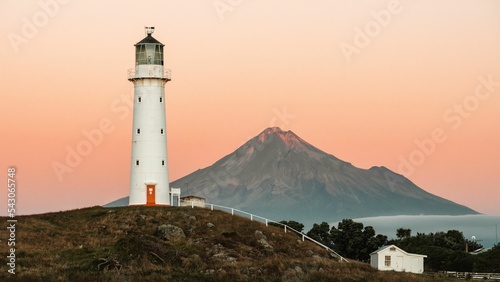 Scenic view of the Cape Egmont Lighthouse against mountain in New Zealand