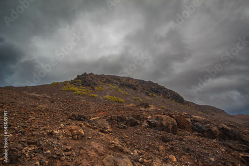 Paisaje volcanico de las Islas Canarias despues de una tormenta tropical en verano  arena y rocas negras de tipo volcanico un precioso mar con colores profundos y olas golpeando a las rocas