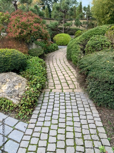 stone path in the garden. carved pavement, natural stone and traditional east plants. Appeltern, Netherlands, October 12, 2022