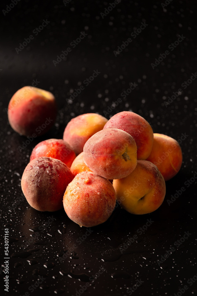 Fresh ripe juicy whole and cut red peaches on rough black background. Fresh ripe juicy whole and cut red peaches on rough black background.