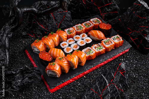 rolls set Hattori Hanzo. Philadelphia California salmon sushi salmon sushi with red caviar on a black background photo