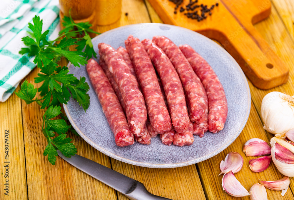 Raw sausages longaniza ready for frying on plate. Traditional Catalan meat products