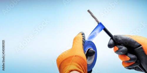 Electrician working with cables wiring. Hands of the electrician using  electrical tape with electricity wire. Banner with copy space.