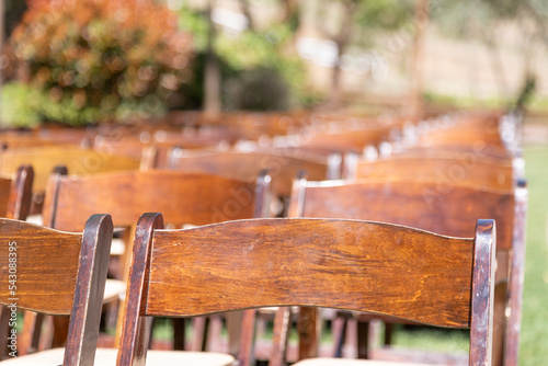 Rows of Wooden Event Chairs at Wedding Venue Abstract. photo