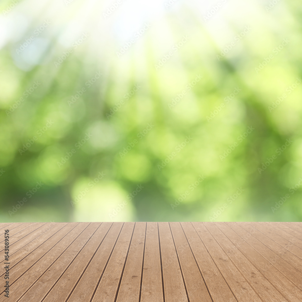 Empty wooden surface against blurred green background. Bokeh effect