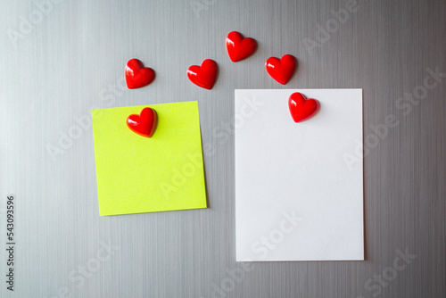 Empty paper sheet on refrigerator door. Note paper with magnetic heart. Valentine send text love message. © pattanawit