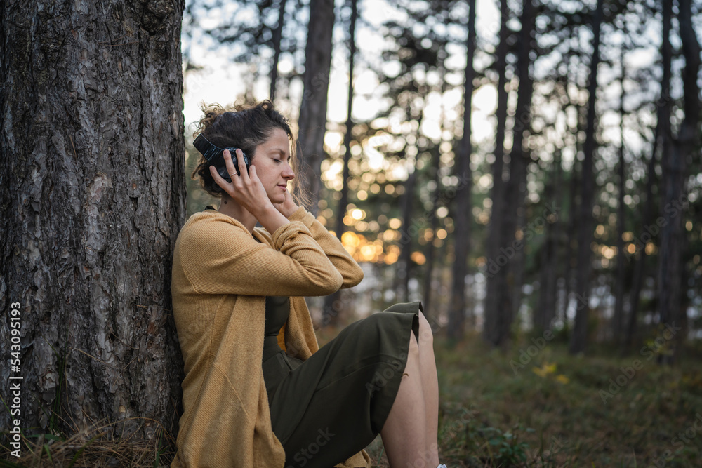 one woman in park or forest online guided meditation self-care concept one woman in park or forest online guided meditation self-care concept