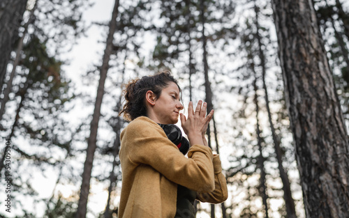 one woman in park or forest online guided meditation self-care concept © Miljan Živković