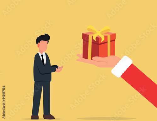 Christmas and new year. The big hand of Santa Claus is giving a businessman a red gift box for the new year and christmas.