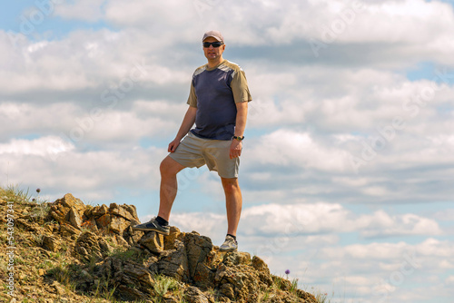 a handsome mature man stands on the kraka ridge in the southern Urals on a summer sunny day