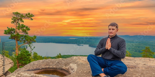 young handsome man on a rock on the Arakul shihan enjoys on a summer day photo