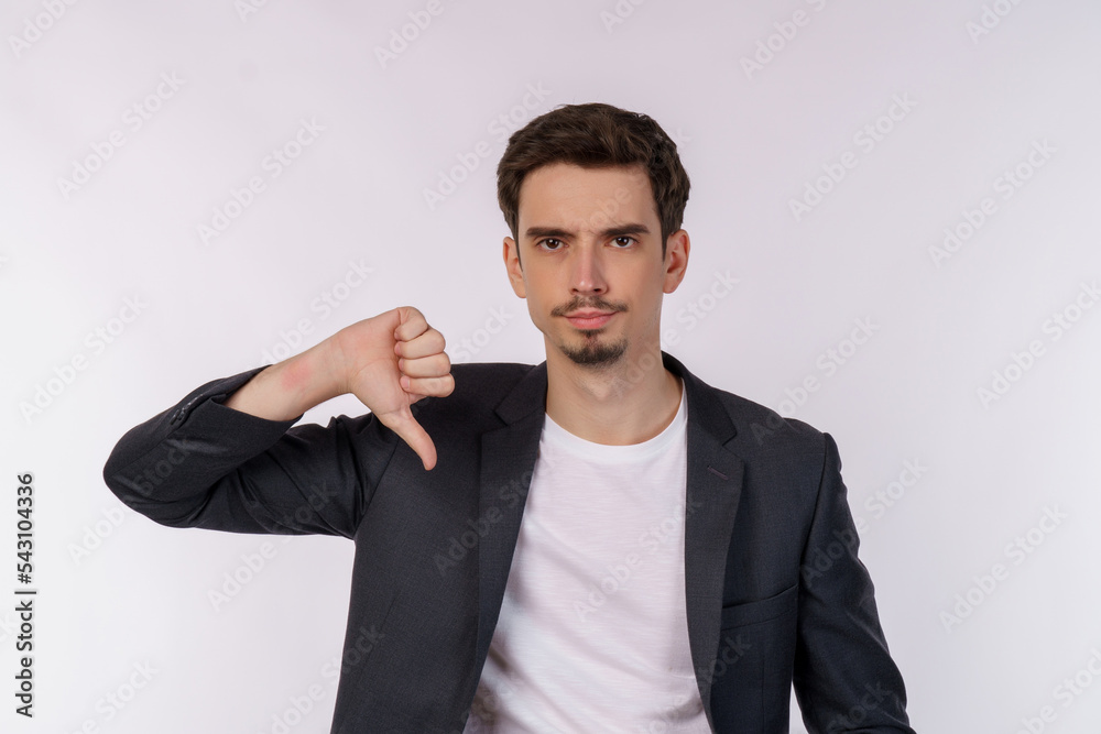 Φωτογραφία Portrait of young businessman shows sign of dislike, looks with negative express