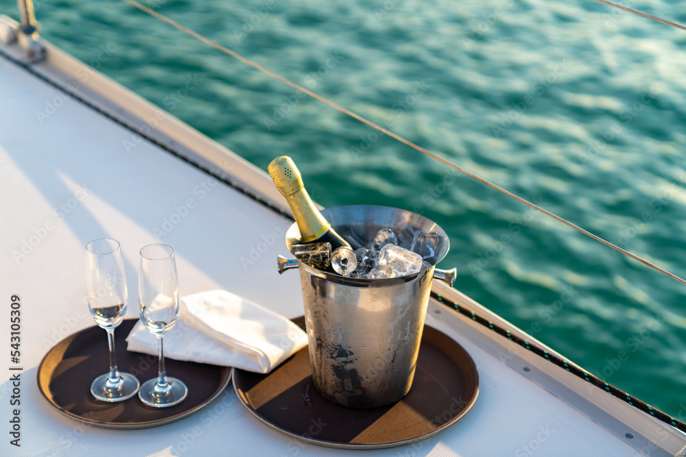 Champagne bottle in ice bucket with champagne glass on the tray for serving  to passenger tourist