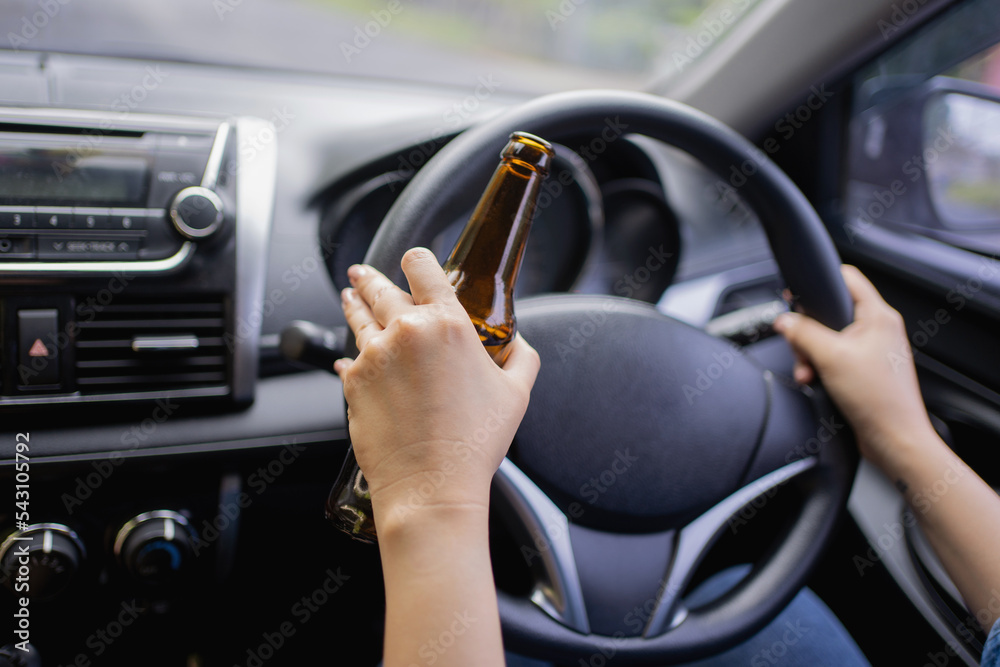Man drinking alcohol while driving in his car Man drinking alcohol while driving in his car
