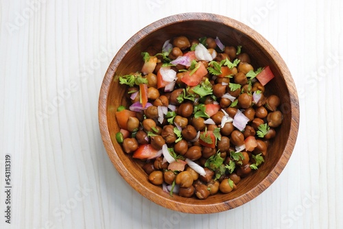 High in protine boiled black chana or chickpea salad. Chopped tomatoes, onion, chilies, and coriander mixed with boiled chickpea or Bengal gram. Weight loss meal. Served with Lemon. Copy space.