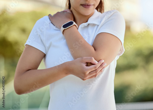 Tennis elbow, sports and a woman with injury, fitness and training game on court. Workout, sport exercise and healthcare, tennis player girl with arm pain or inflammation, accident at outdoor match. photo