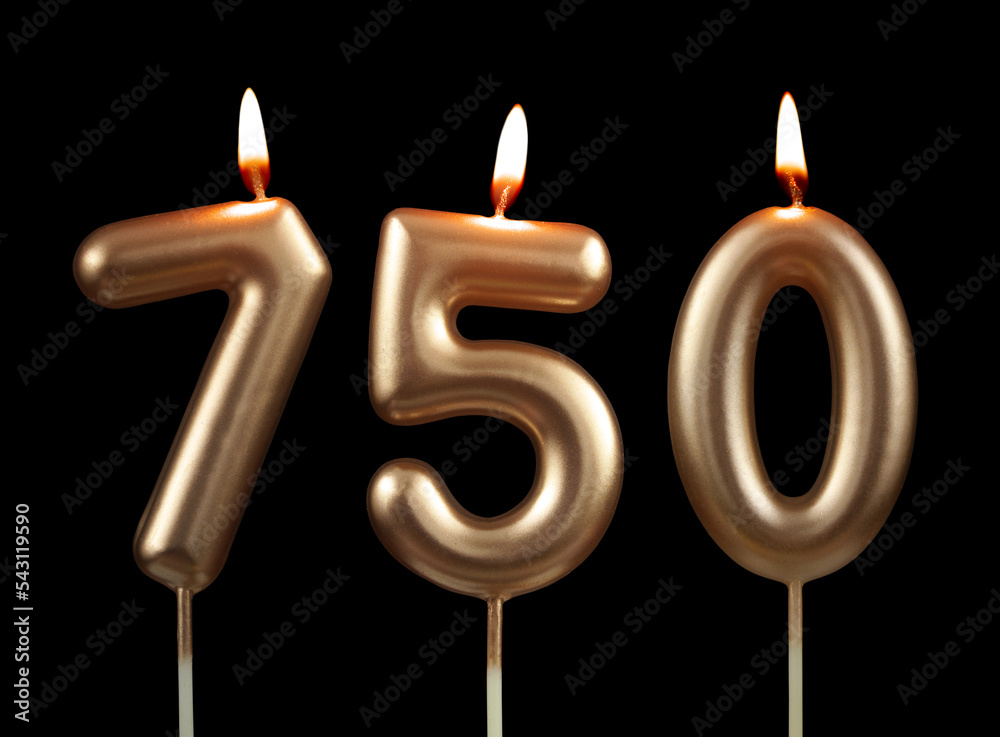 Burning golden birthday candles isolated on black background, number 750 Burning golden birthday candles isolated on black background, number 750