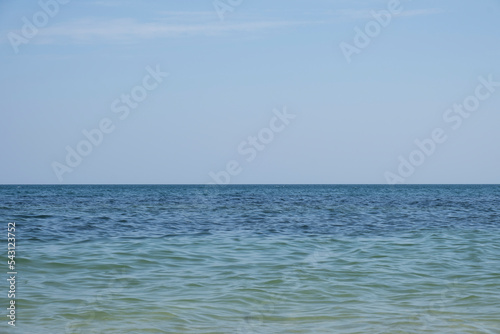 Panoramic view of the blue calm sea and blue clear sky on a summer day on the coast. Sunny skies and calm blue oceans. Bright sea, horizon