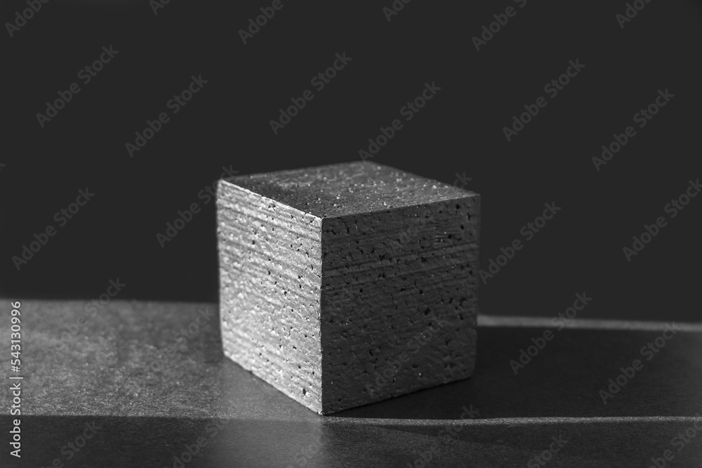 Black square pedestal in ray of sunlight on dark background. Concept of 3d podium for presentations of packaging and cosmetics. Close-up, copy space Black square pedestal in ray of sunlight on dark background. Concept of 3d podium for presentations of packaging and cosmetics. Close-up, copy space