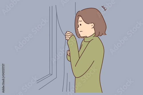 Scared unhappy woman look out of window feel anxious 
