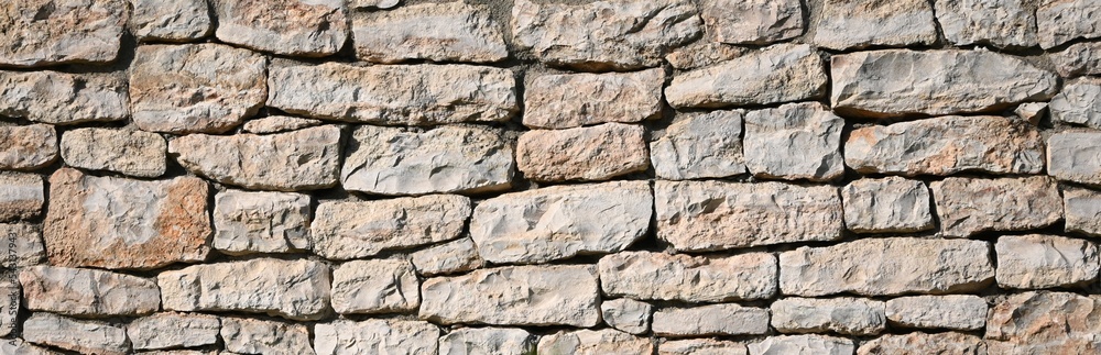 Fototapeta premium Fondo con detalle y textura de muro de piedras naturales en tonos marron suave