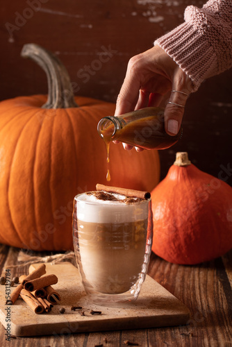 Woman hand holding homemade pumpkin spice latte made from scratch with pumpkin spice syrup