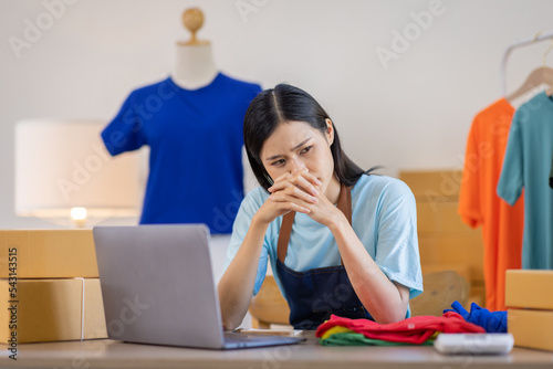  Startup small SME business entrepreneur of independent, Asian woman Sad uncheerful unsuccessful Online selling work on laptop computer at home, marketing package box items SME delivery ideas.