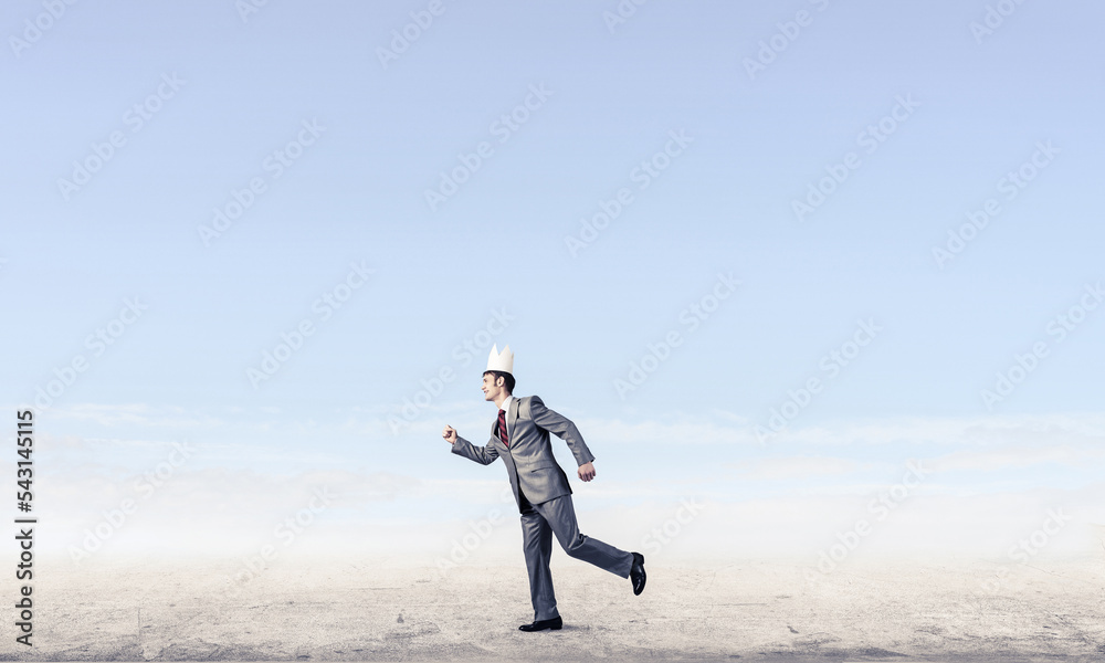 King businessman in elegant suit running and blue sky at background King businessman in elegant suit running and blue sky at background