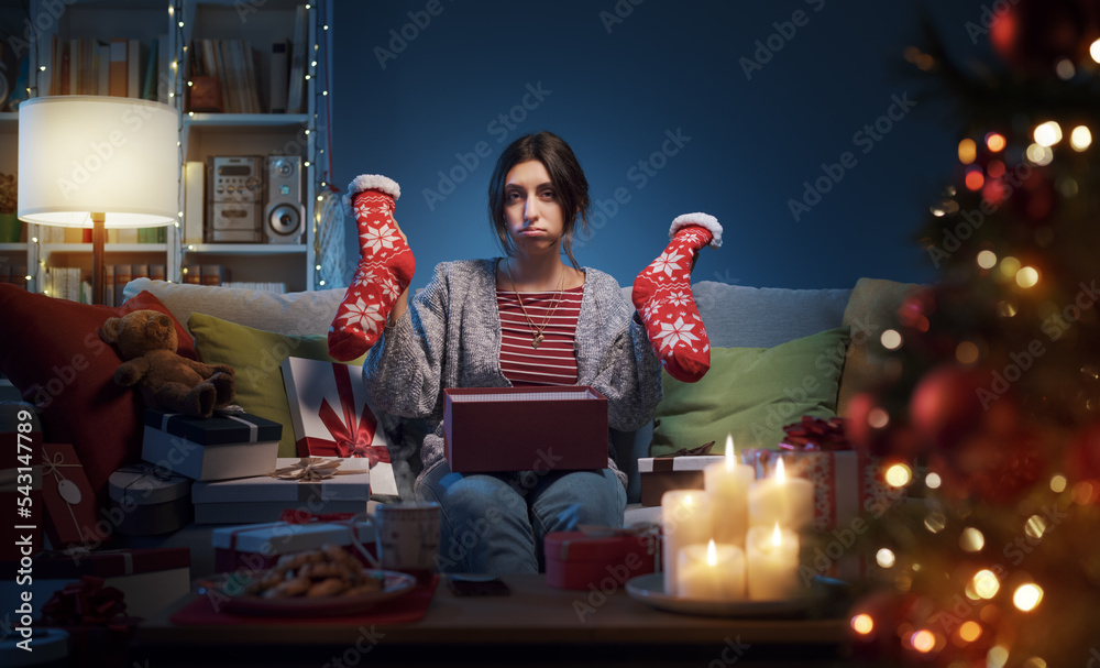 Fototapeta premium Disappointed woman opening Christmas gifts