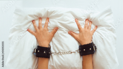 Female hands in black handcuffs, sex toys