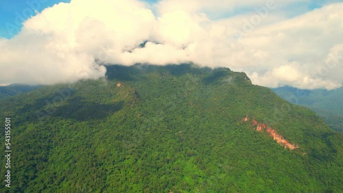 Drone flying over a tropical forest in the early morning at sunrise, mist covering the green mountains. green nature and travel concept. Chiang Dao District, Chiang Mai Province, Northern Thailand.
 photo