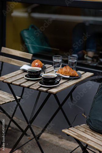 Obraz na płótnie Black coffee with croissants on the table. Aromatic coffee outside. Break to meet a girlfriend. Coffee for two w salonie