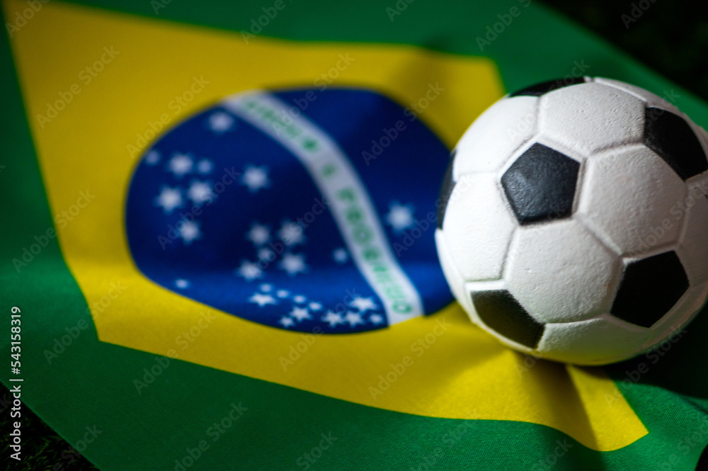 Naklejka premium Brazil national football team. National Flag on green grass and soccer ball. Football wallpaper for Championship and Tournament in 2022. World international match.