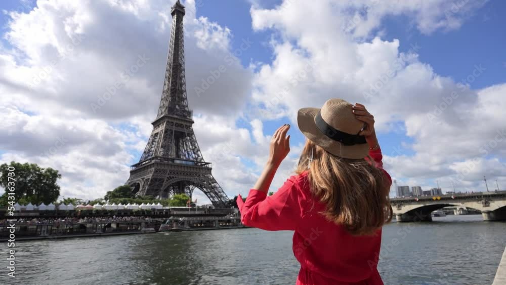 Holidays in Paris. Back view of beautiful fashion girl enjoying view of Eiffel Tower in Paris, France. Summer vacation in Europe.
