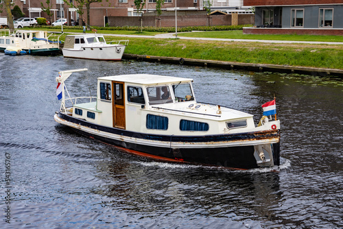 Recreational boat on a canal in the Netherlands on a cloudy summer day. Water.
