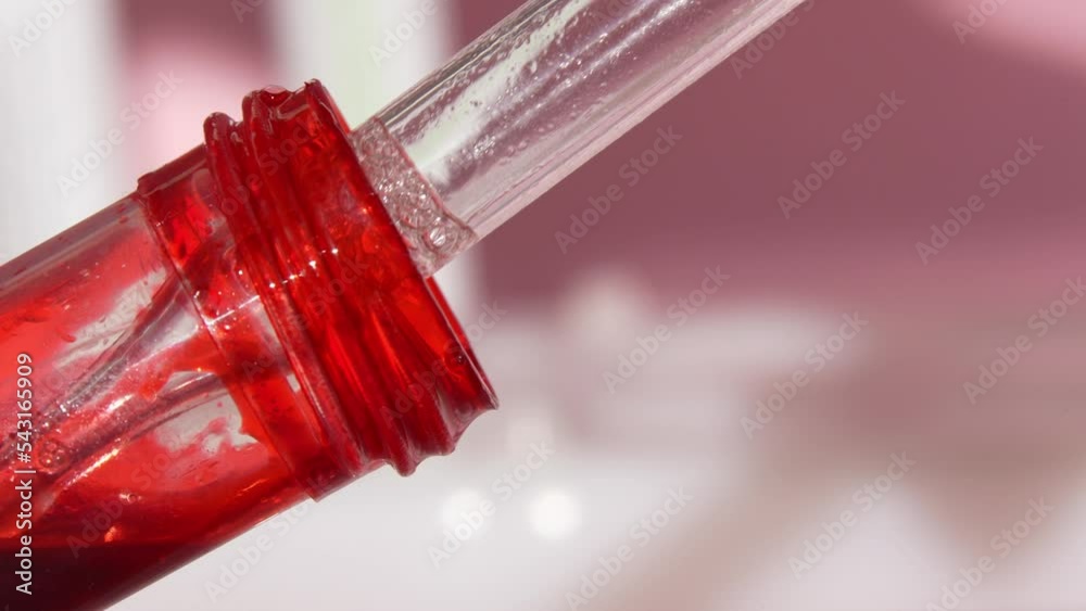 The drop in the pipette of blood. Test tube with biomaterial close-up. The concept of developing a pharmaceutical drug for the treatment of diseases with the help of drugs that improve DNA.Slow motion The drop in the pipette of blood. Test tube with biomaterial close-up. The concept of developing a pharmaceutical drug for the treatment of diseases with the help of drugs that improve DNA.Slow motion