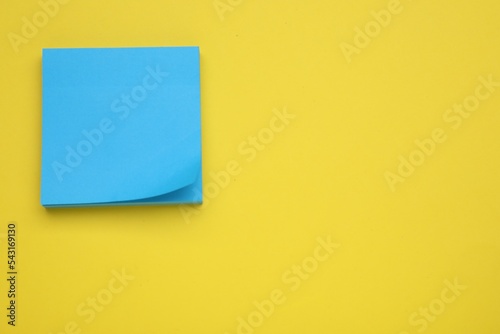 Paper note on yellow background, top view. Space for text