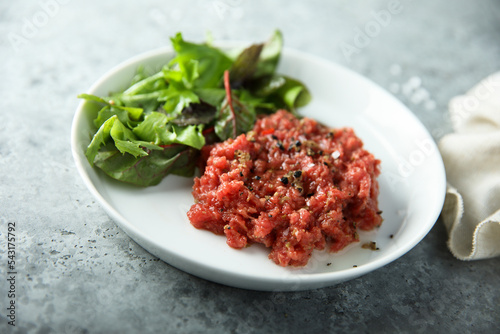 Fotografi Traditional homemade steak tartare with leaf salad