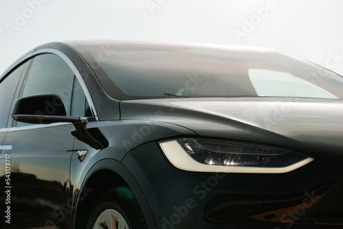 Luxury modern black vehicle at sunset. Charging electric car. Alternative energy for Electric Vehicles. SUV all-electric car. Eco friendly green environment concept © uflypro