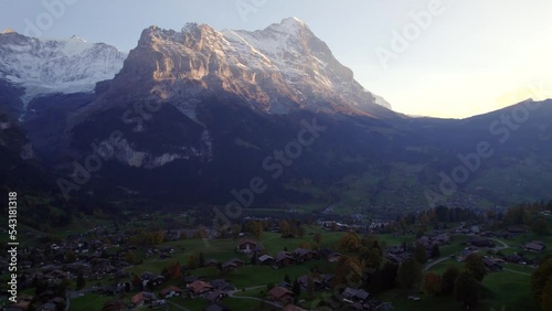 aerial drone footage pushing out over Grindelwald village, sunset view of Mount Eiger (North Face) photo