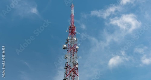 Transmission tower against fast moving clouds and blue sky