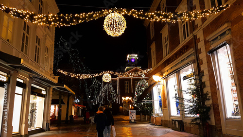 Danish city street decorated with christmas lights glowing at night in December
