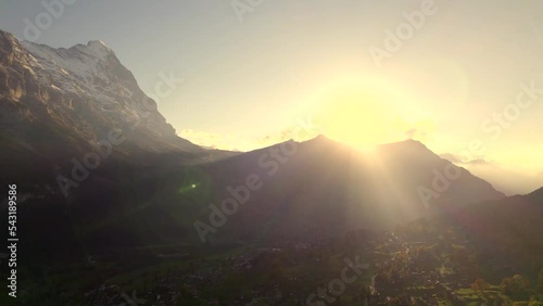 aerial drone footage pushing in over Grindelwald with sunset view of Eiger North Face photo