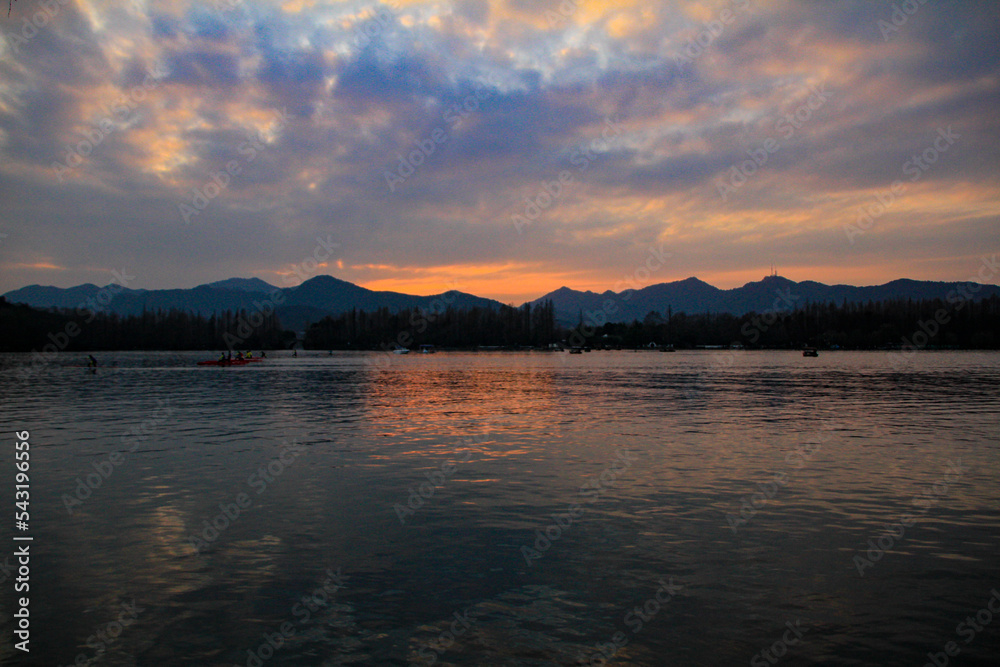 A seascape with mountains at colorful sunset.  West Lake. Popular park of Hangzhou city China