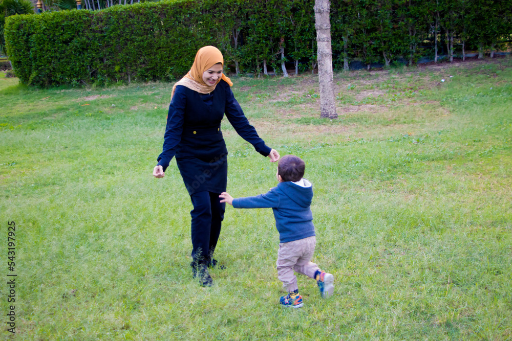 a child running with her mother on garden with green yard , Family playing time concept a child running with her mother on garden with green yard , Family playing time concept